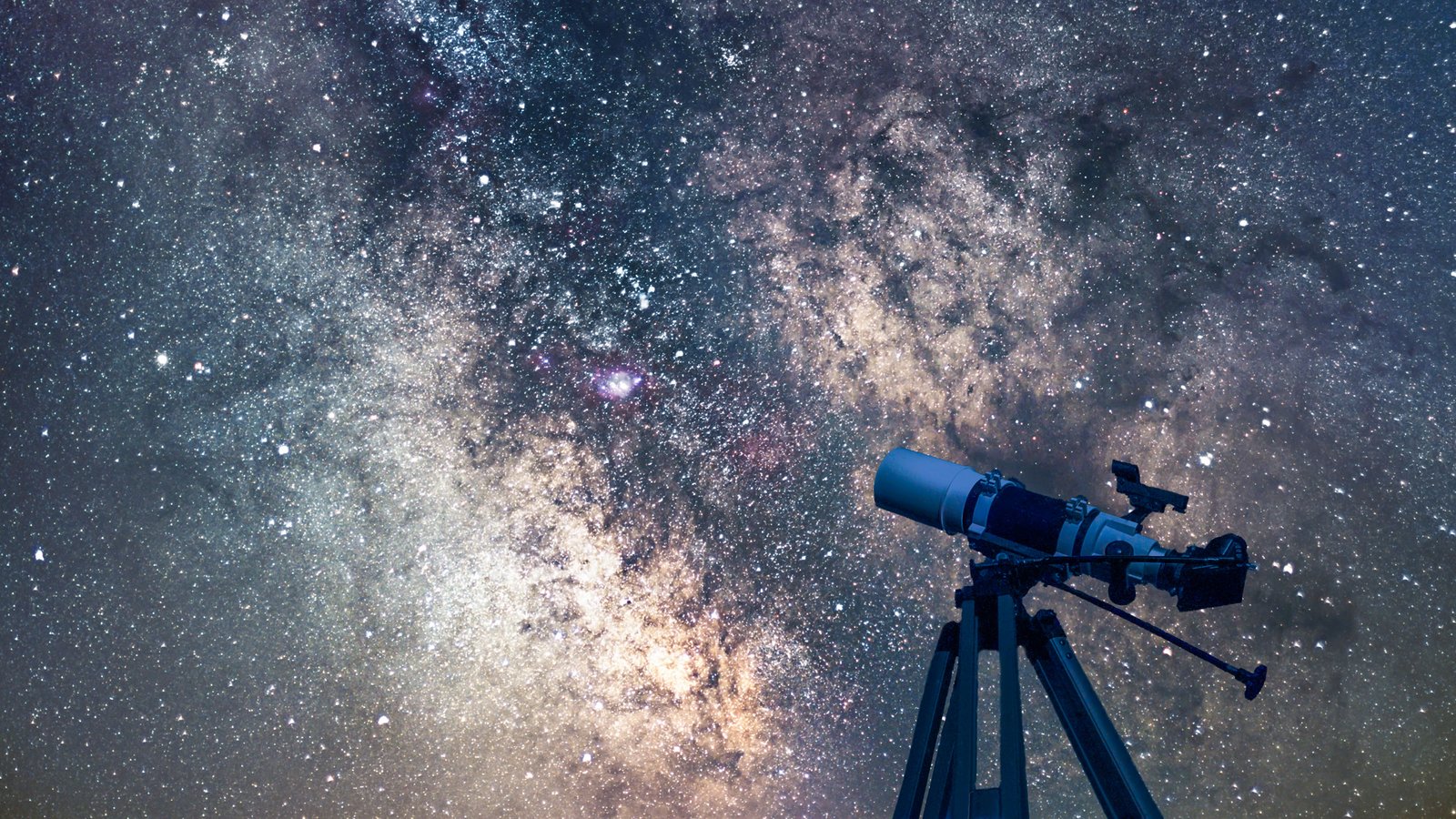 A telescope silhouetted against the Milky Way on a clear night