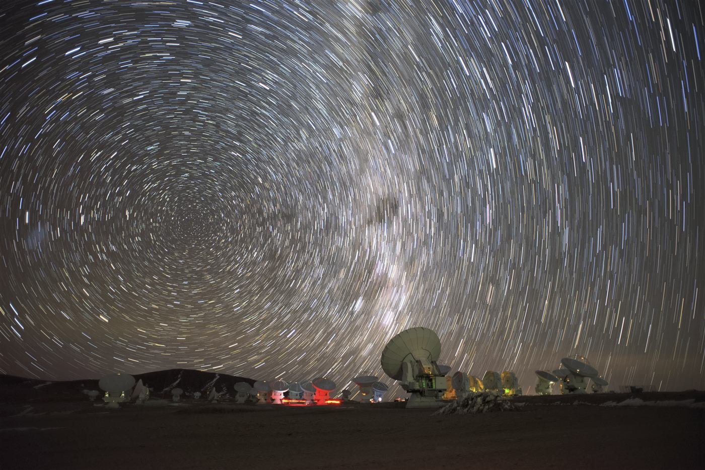 Circumpolar star trails circling the celestial pole above an observatory
