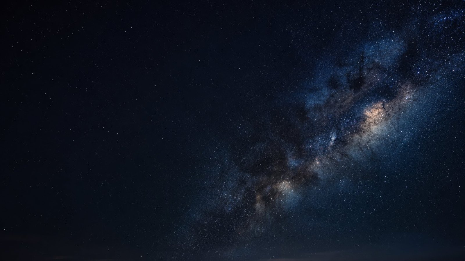 The Milky Way's galactic core rising over a dark sky, dense with stars and dust lanes